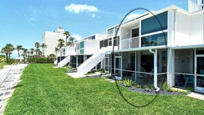 A modern multi-story house with a well-maintained lawn, a staircase leading to the upper levels, and a clear view of the surrounding area.
