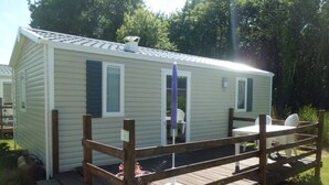 A single-story mobile home with a fenced deck and a small patio area.
