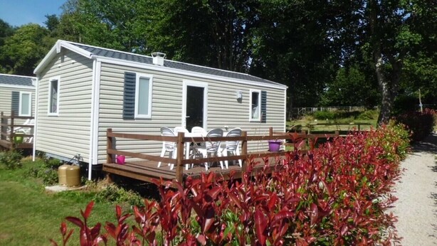 A mobile home with a deck and outdoor seating area.
