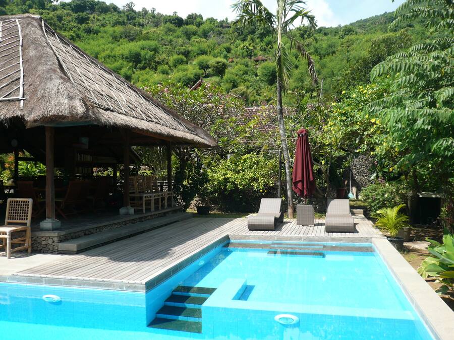 Una piscina al aire libre, sombrillas, tumbonas