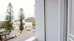 A narrow balcony with a view of a street and buildings. - Rusty inn (Hengchun)