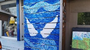 A blue wooden structure with white wing silhouettes, possibly a decorative piece or art installation. - Rusty inn (Hengchun)