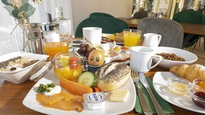 Ein Frühstücksbuffet mit verschiedenen Speisen, darunter Eier, Toast und Obst.