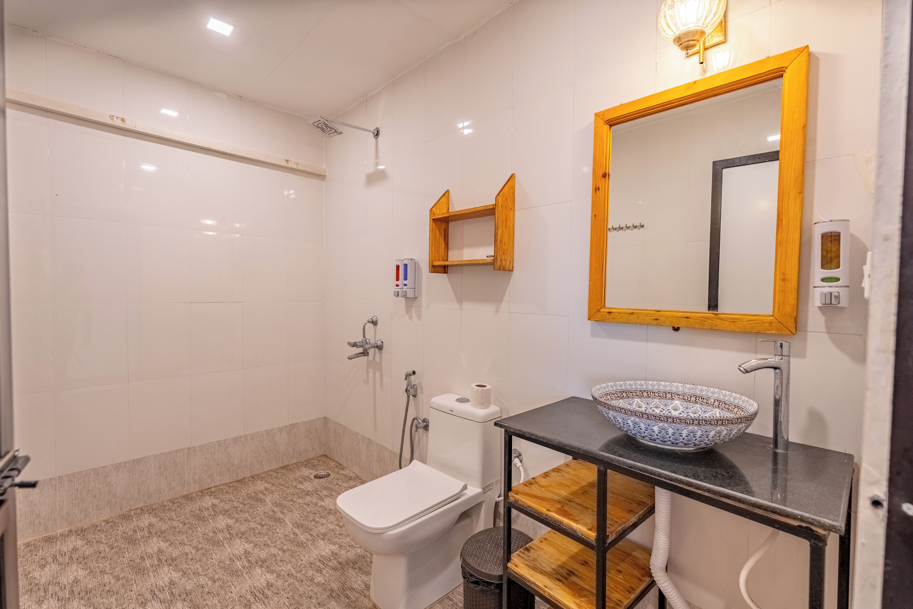 A modern bathroom with a white toilet, a sink with a patterned bowl, and a wooden vanity.
