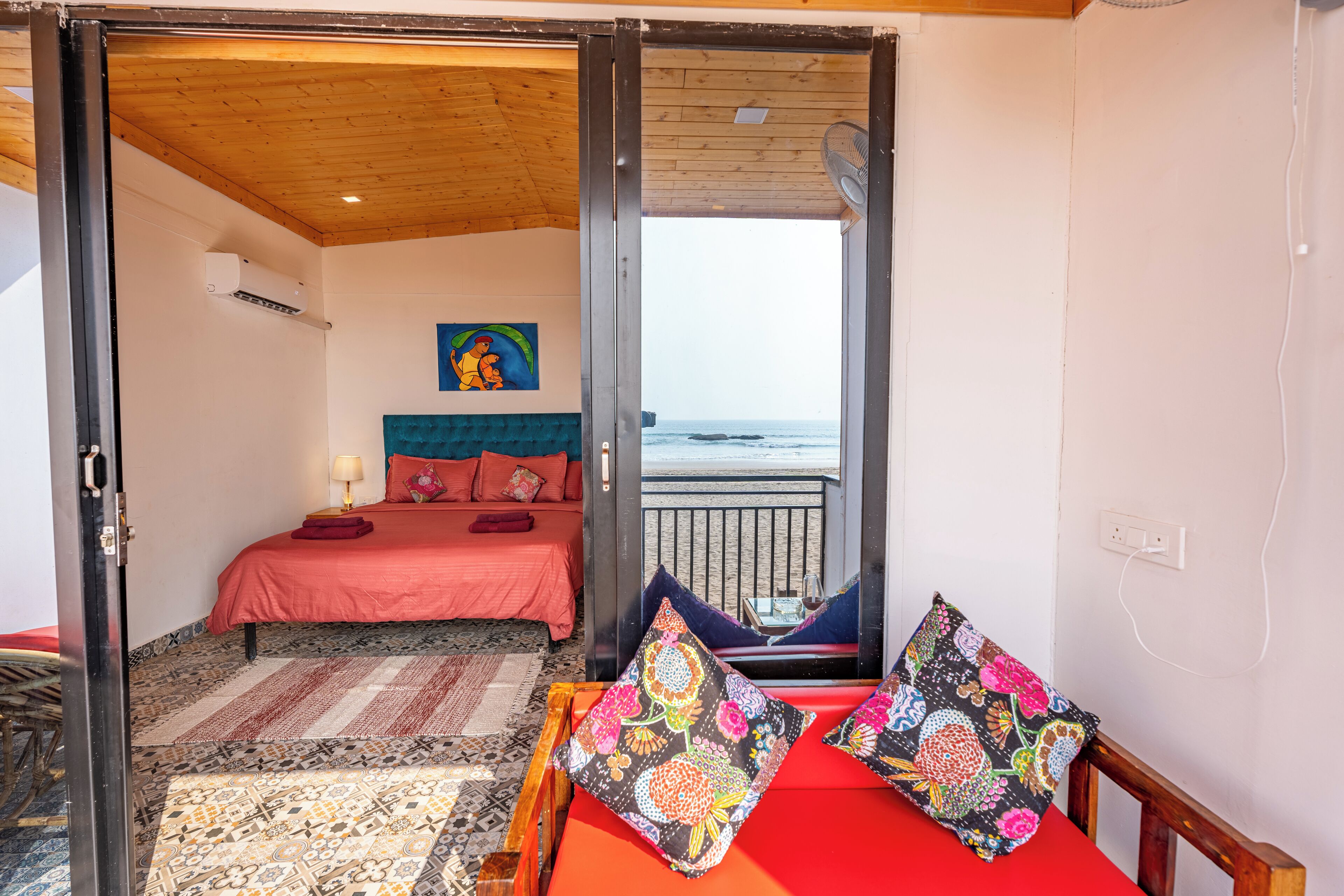 Une chambre avec un lit, une vue sur la mer et un balcon équipé d’une chaise.