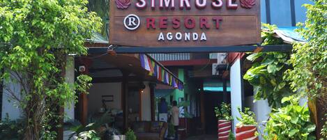 A wooden sign for Simrose Resort in Agonda, featuring a logo and the name of the resort.