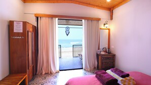 A bedroom with a bed, a wooden wardrobe, a bathroom with a sink, and a view of the beach. - Simrose Resort South End of Agonda Beach (Canacona)