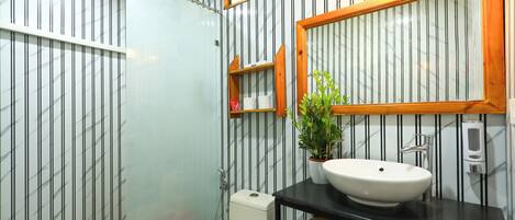 A bathroom with a toilet, sink, and shower.