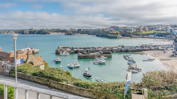 Una cittadina costiera con un porto turistico, edifici e una strada che conduce al porto.