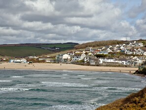 A coastal town with houses along the beach and a view of the sea.