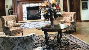 A lobby with a fireplace, two patterned armchairs, a coffee table, and a chandelier. - 3 bedroom, 3 bath, indoor and outdoor pools, 2nd floor in gated Pointe Royale (Branson)