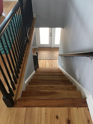 Stairs lead to a landing area with a woven rug.