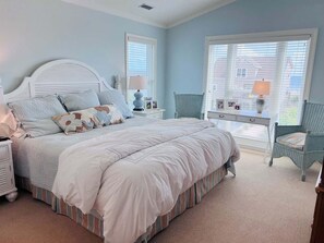 Un dormitorio con cama, mesitas de noche, escritorio y silla.