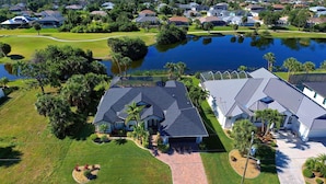 A residential area with houses, a pond, and a golf course. - Bella Vista | Pool | Spa | Lake front | Lounge (Rotonda West)
