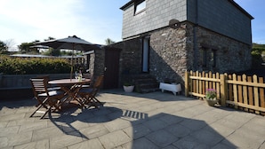 A stone building with a wooden deck and outdoor seating.
