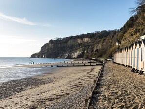 A beach with wooden structures, a rocky shoreline, and cliffs in the background. - 2 bedroom accommodation in Shanklin (Shanklin)
