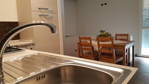 Eine moderne Küche mit einer Edelstahl-Spüle, einem Gasherd und Holzkästen um einen Tisch.