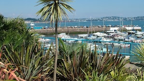A marina with boats docked, surrounded by greenery and a clear sky. - Comfort and luxury in a sea front location with panoramic sea views. (Paignton)