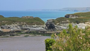 Eine Küstenlandschaft mit felsigen Klippen, einem Strand und freiem Blick auf das Meer.