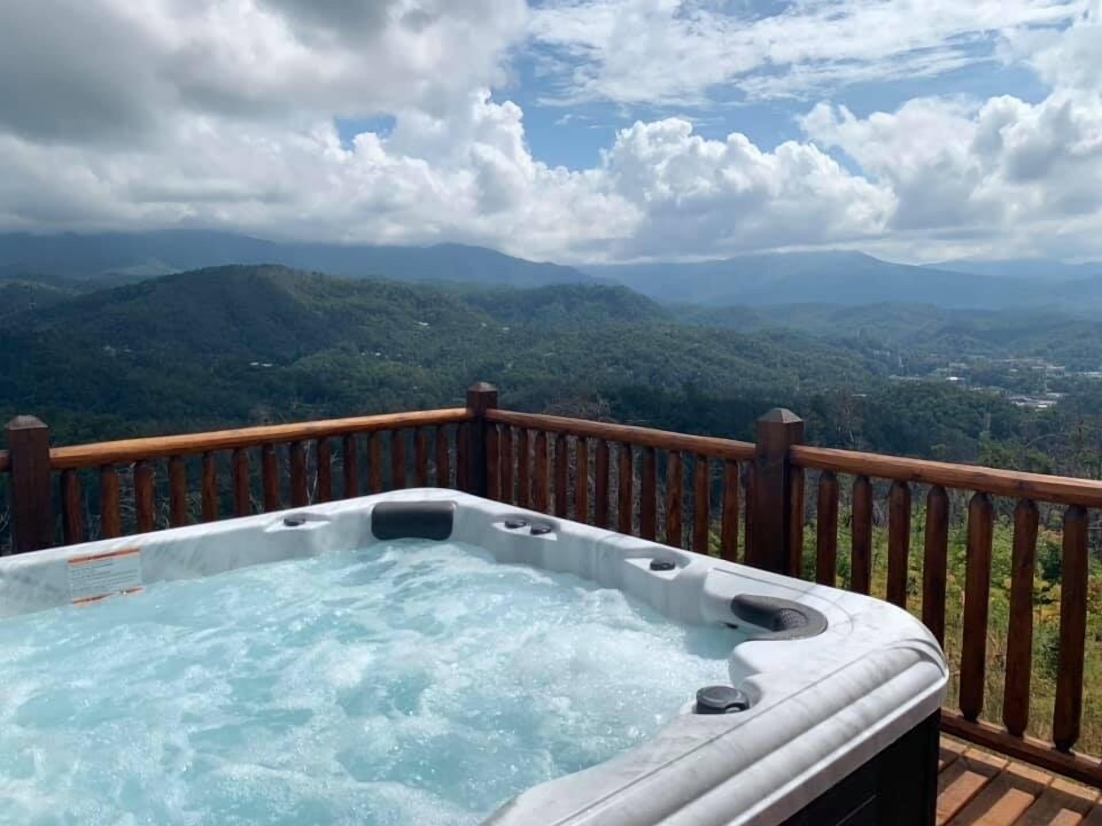 Un jacuzzi en una terraza de madera con vistas a la montaña.