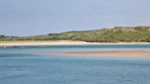 A coastal beach with boats, a sandy shore, and a hilly background. - Trevistas, Padstow, Cornwall (Padstow)