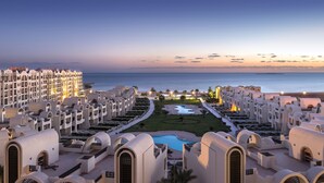 A resort with multiple white buildings, a central pool, and a view of the sea. - Gravity Hotel Aqua Park Sahl Hasheesh Families and Couples Only (Sahl Hasheeh)
