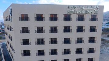 A multi-story hotel building with balconies and a clock on the facade.