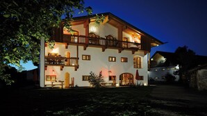 A two-story building with a balcony, wooden beams, and multiple windows.