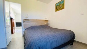 Ein Schlafzimmer mit einem großen Bett, einem Fernseher und einem Bild an der Wand.