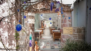 A narrow alleyway leading to a restaurant named Moshinos. - Moshinos Otel (Ayvalik)