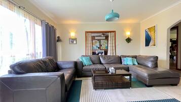 A living room with a sofa set, a coffee table, and a hanging light fixture.