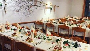 A dining area with multiple tables set for a meal, each with white tablecloths, neatly folded napkins, and glassware. - Hotel Schiffahrt (Quarten)