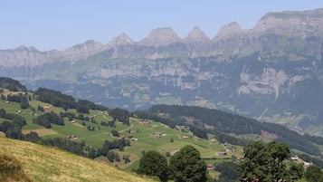 A mountainous landscape with scattered houses and green fields.