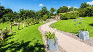 Un sentier de jardin menant à un belvédère agrémenté d’une terrasse.