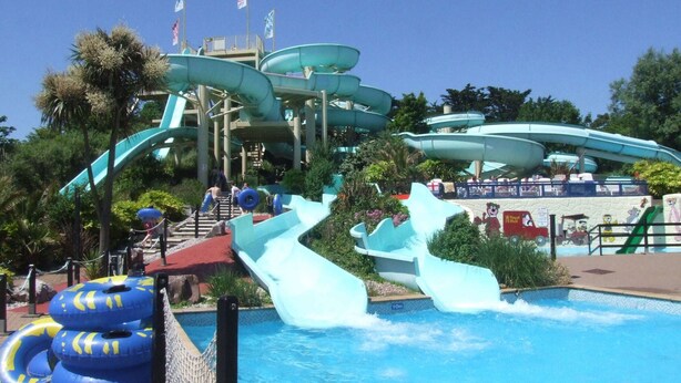 Een waterpark met meerdere glijbanen en een zwembad.