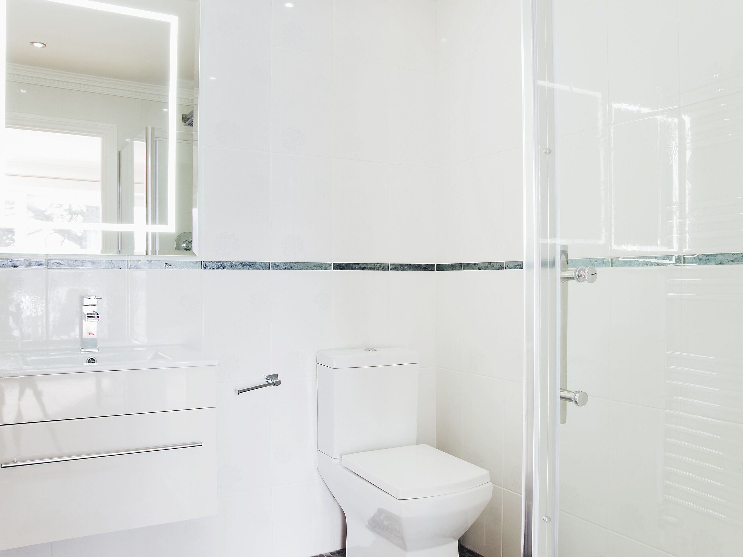 A modern bathroom with a toilet, a sink, and a mirror.