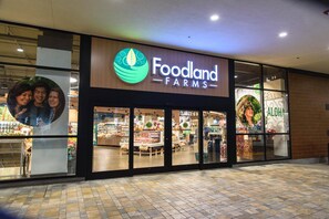 Ein Foodland Farms Geschäft mit einer großen Schautafel, Glasfenstern und einem gefliesten Boden.