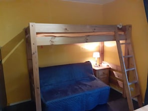 Cozy retreat with a single bunk bed, bedside table, and lamp for a comfortable stay.