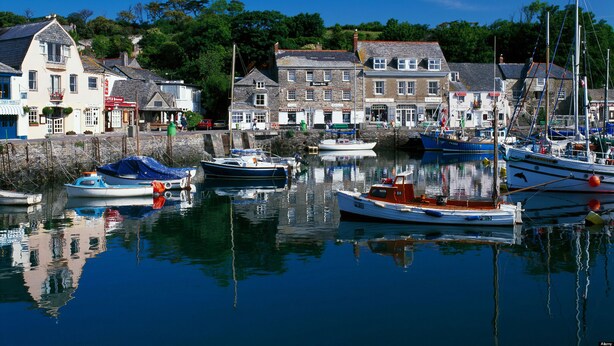 A harbor with boats docked, buildings with shops, and a clear blue sky. - 4 bedroom accommodation in Padstow (Padstow)