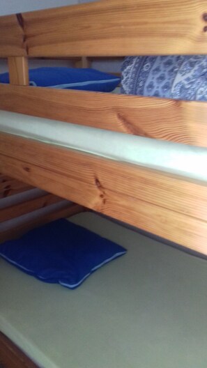 Un lit superposé avec une structure en bois et un matelas.