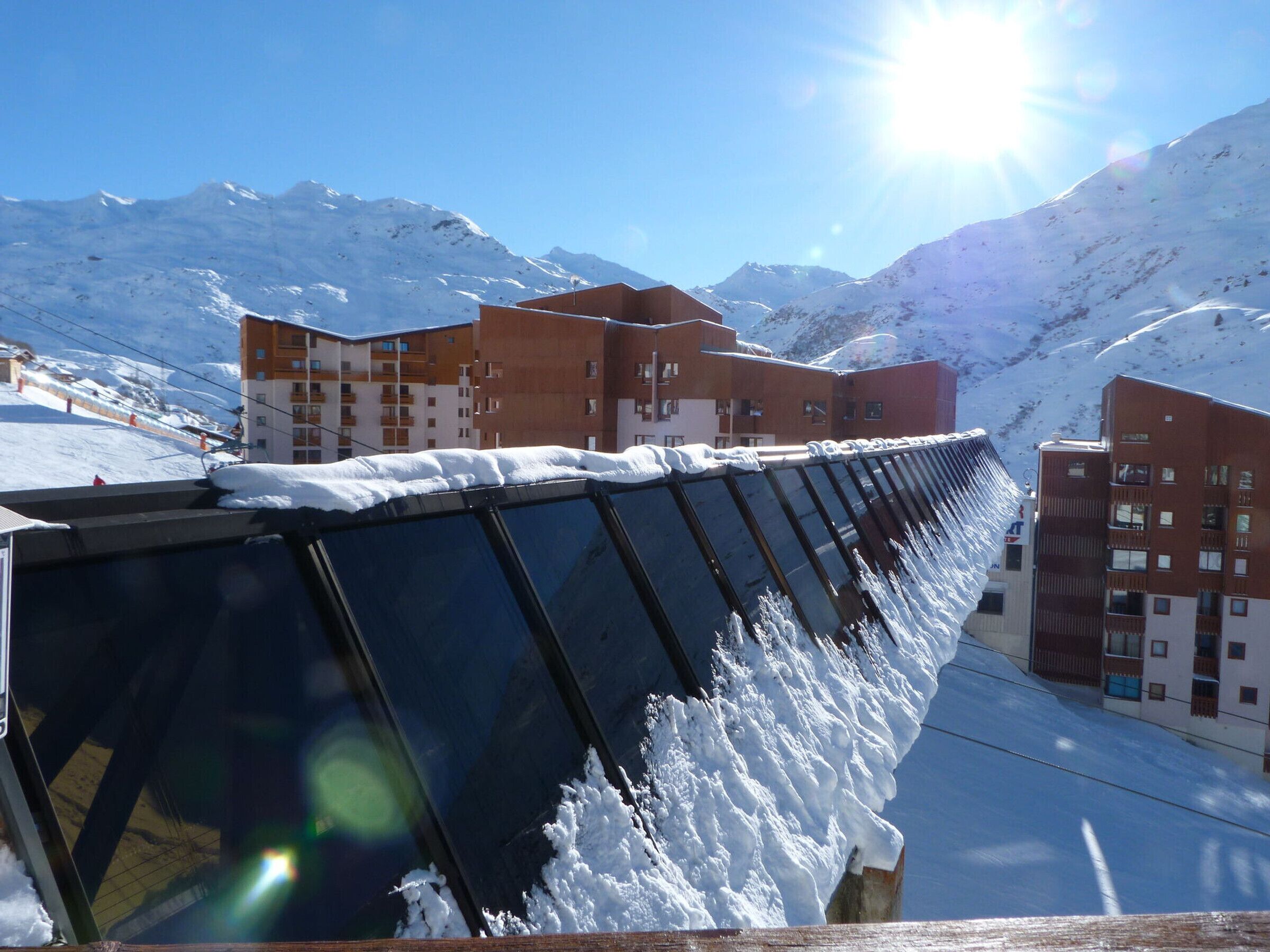 Une rangée de bâtiments avec une montagne enneigée en arrière-plan.