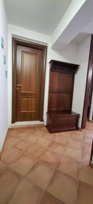 A hallway with a wooden door and a wooden bench.