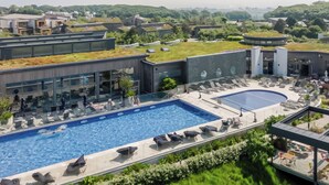 A rooftop swimming pool with lounge chairs and a separate pool area.