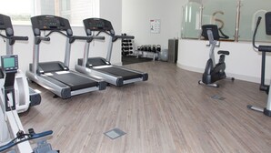 A gym with treadmills, an elliptical, and free weights.