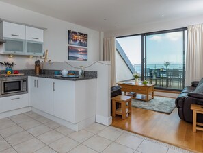 Una cocina moderna con comedor, sofá y vista al mar.