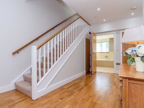 A staircase with white railings and wooden handrails, leading to a bathroom with a bathtub and a sink. - 3 bedroom accommodation in Westward Ho! (Westward Ho!)