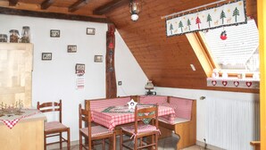 A dining area with a table set for four, wooden chairs, a wooden bench, and a radiator. - Homerez - House in Triembach-au-Val (Triembach-au-Val)
