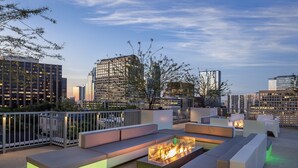 A rooftop lounge with a fire feature and seating. - Downtown Austin 2 Bedroom Deluxe with Rooftop Pool in the Heart of everything (Austin)