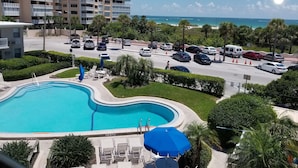 Un hotel con piscina, estacionamiento y vista al océano.