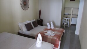 A hotel room with two beds, a small table, a chair, and a kitchenette. - Pousada Ecobaía (Baia Formosa)